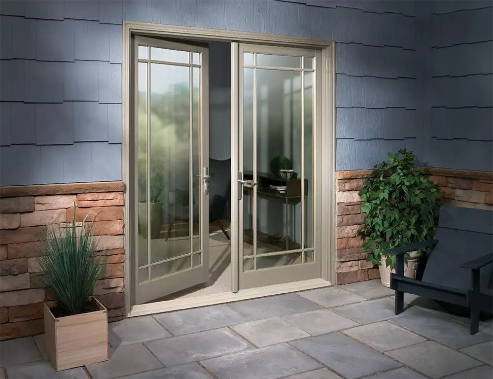 Exterior patio image featuring a 2-panel open Inswing French Door with Prairie 9-Lite Simulated Divided Lites in Pebble Gray exterior finish with Brushed Chrome hardware and a Beige sill