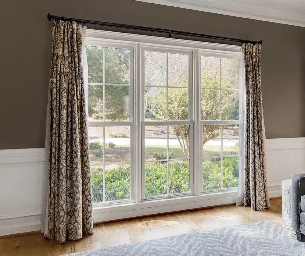 Living room view of Marvin Replacement Double Hung windows with curtains opened to either side.