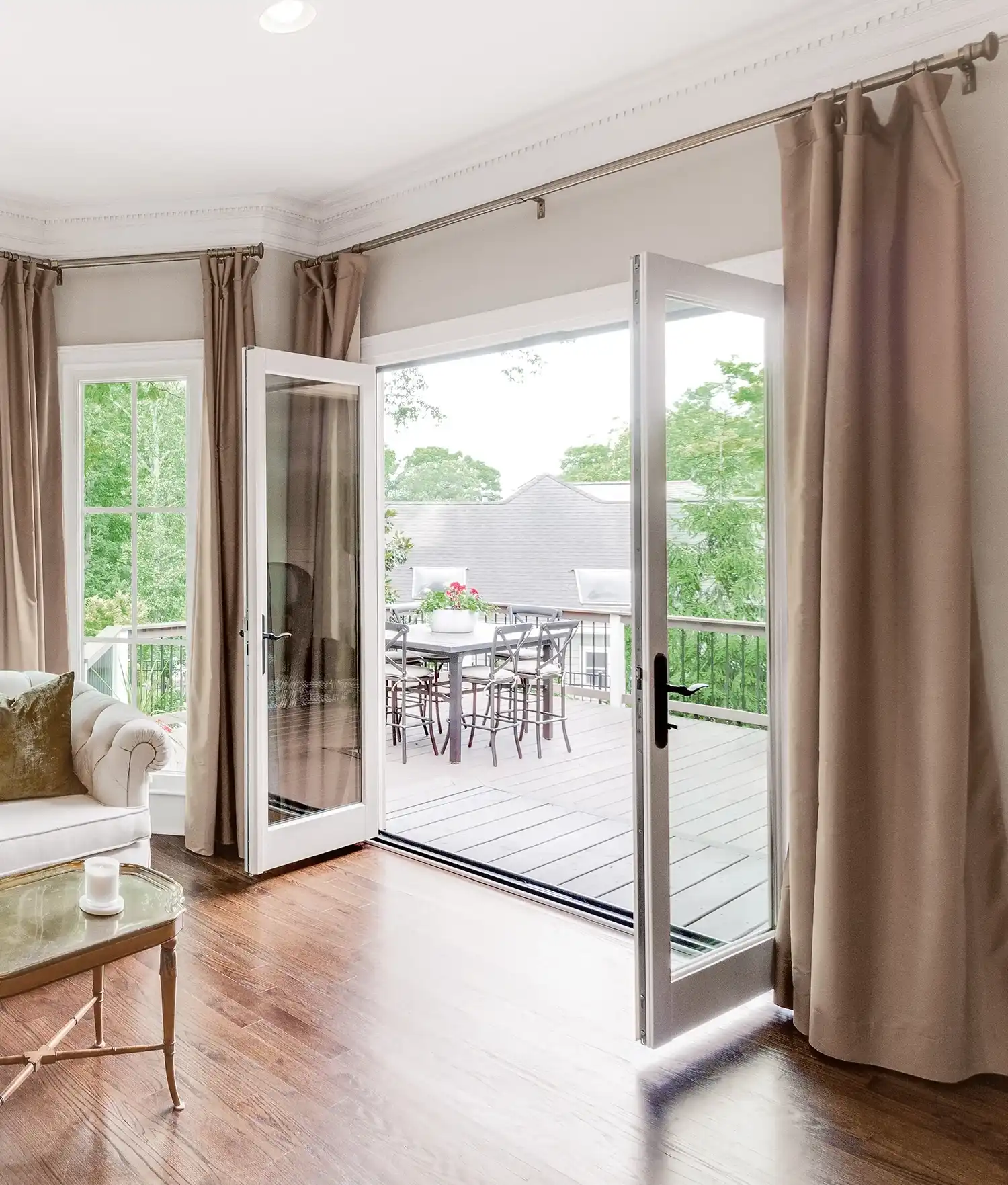 Interior view of a white Marvin Replacement two-panel Inswing French door that opens to a deck