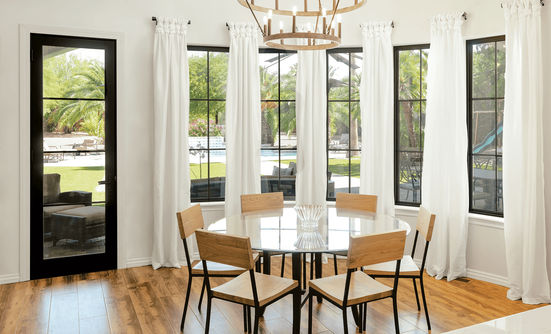 Dining room interior view featuring wood table, Marvin Replacement black windows with grilles..