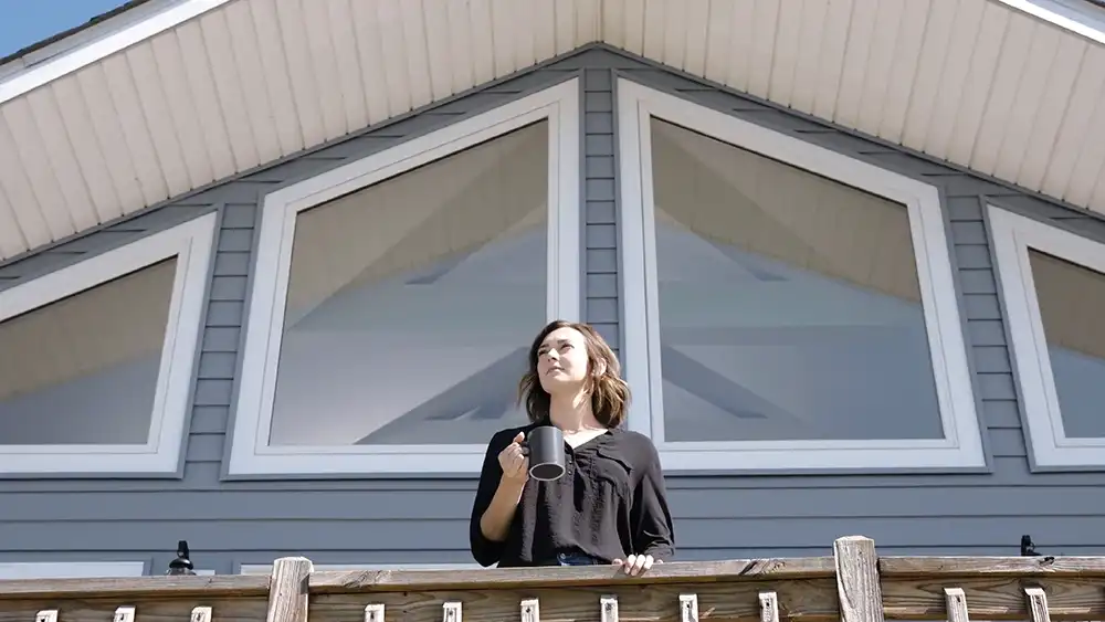 Woman standing on deck in front of picture windows