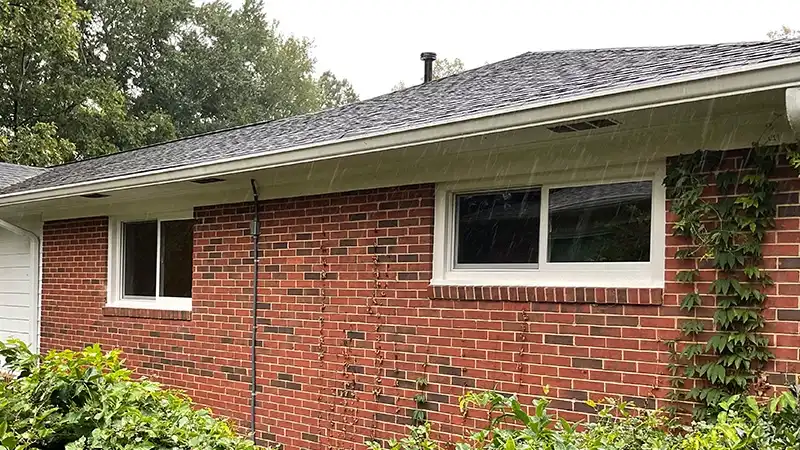 Exterior view of a one-story brick home feature white Marvin Replacement Slider Windows.