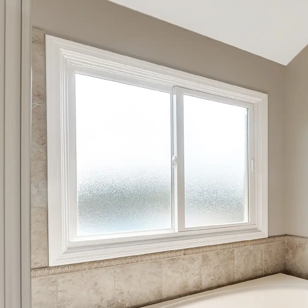 Interior view of a Marvin Replacement slider window in a bathroom with decorative glass.