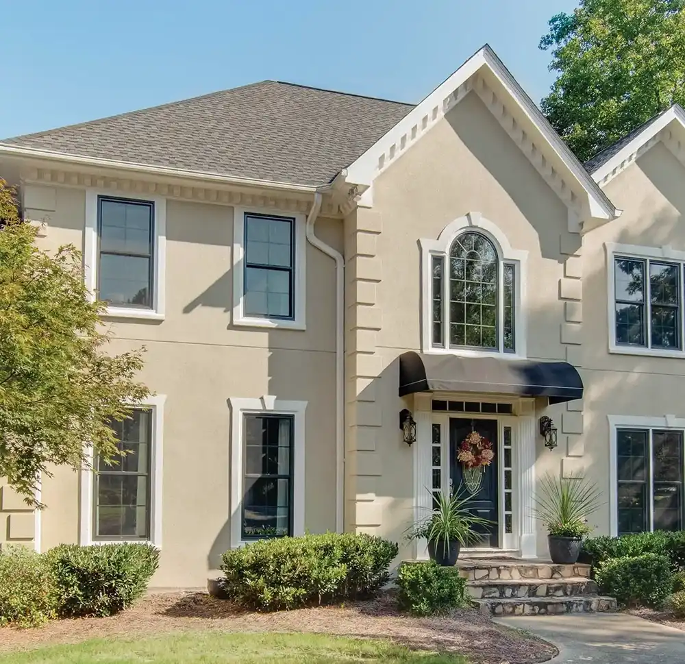 Exterior view of Marvin Replacement Double Hung windows on a beige stucco home.