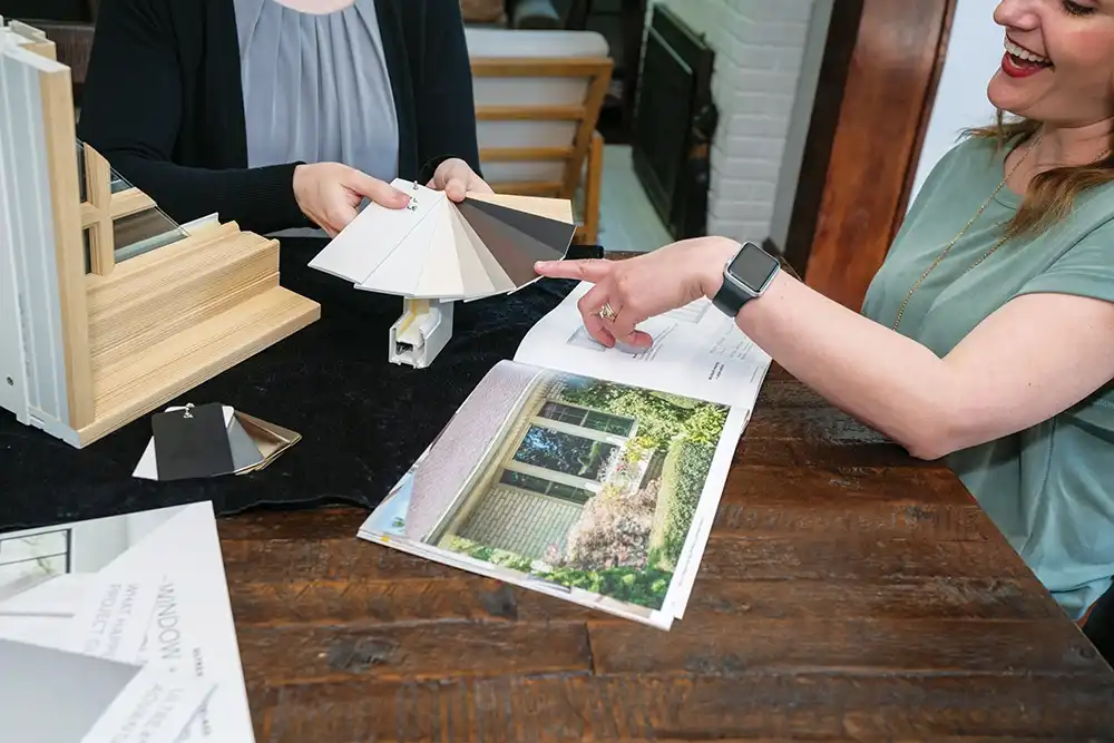 A woman points to window color samples.