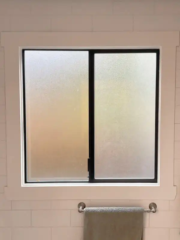 Interior view of a bathroom slider window with privacy glass.