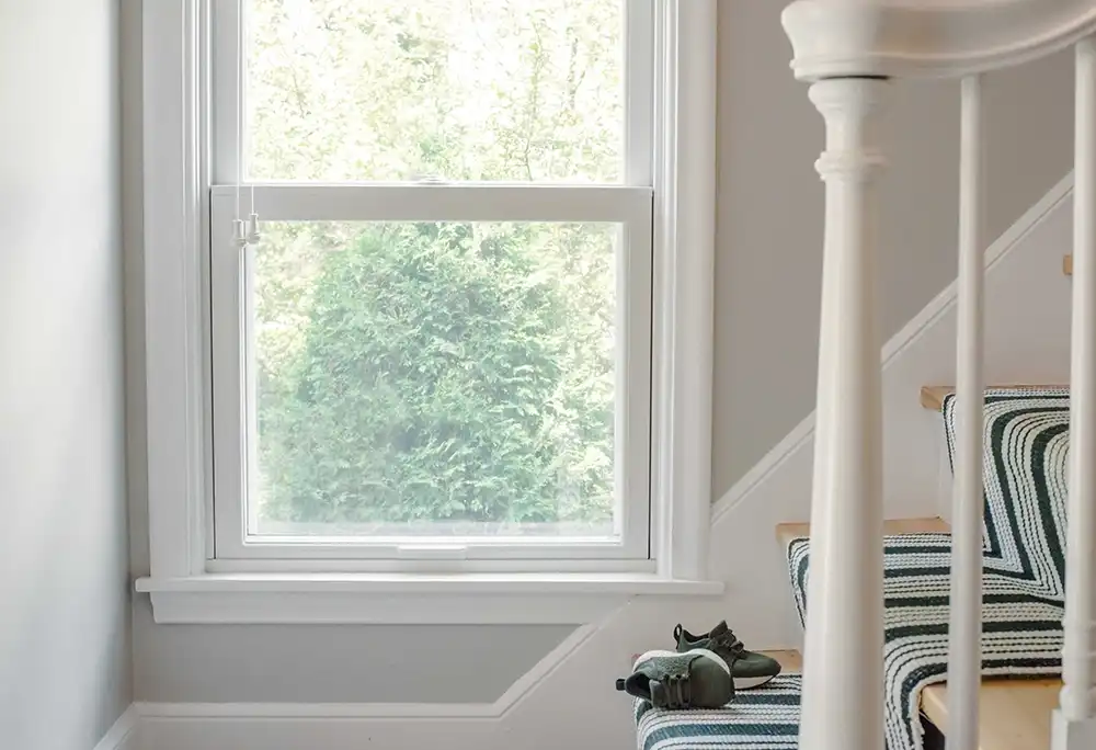 A white Marvin Replacement Double Hung window along a staircase