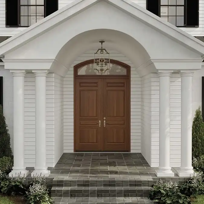 Exterior view of a brown front door with transom window on white house.