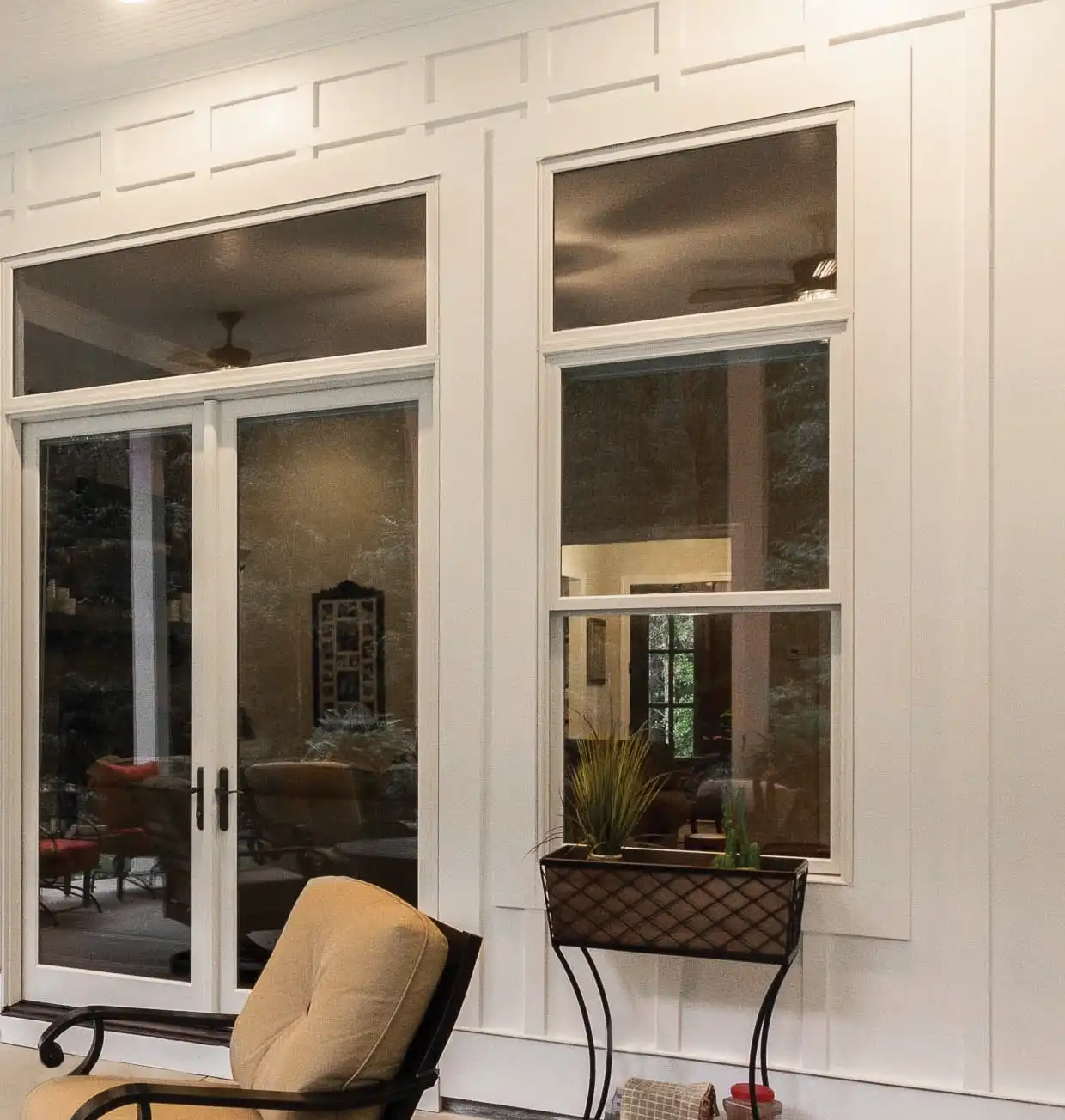 Exterior view of a white Marvin Replacement Double Hung window next two a two-panel French door.