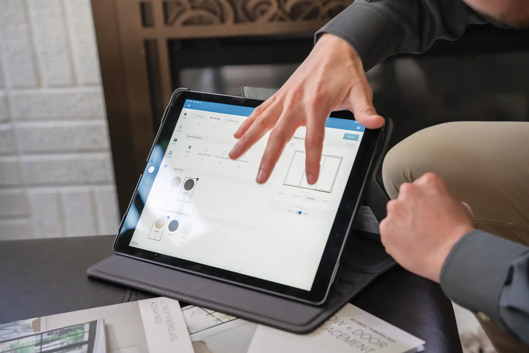 A Marvin Replacement design consultant points to options on a tablet computer inside a home.