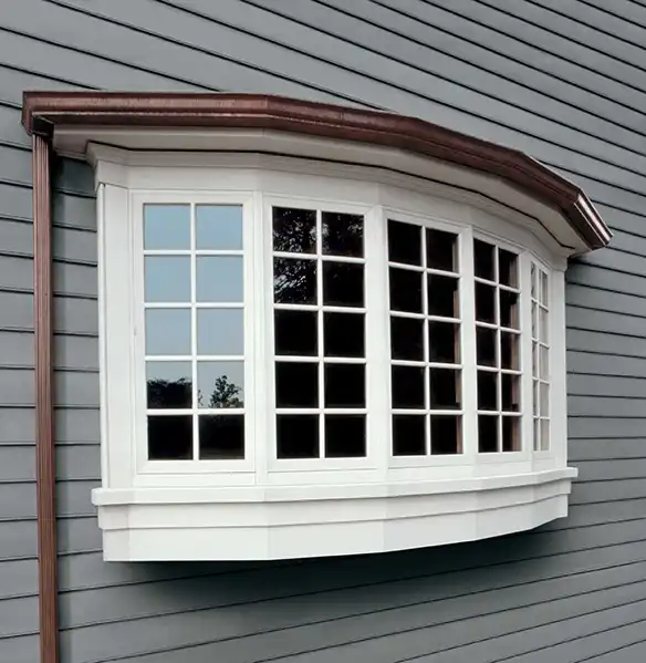 Exterior view of a five-panel white Marvin Replacement Bow window on a gray house.