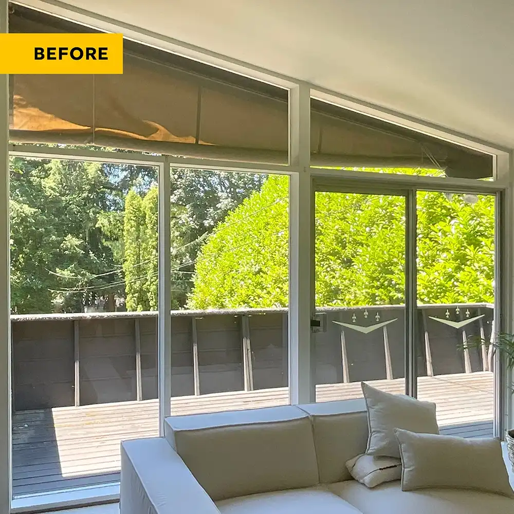 Before image of a living room with white windows and patio door.