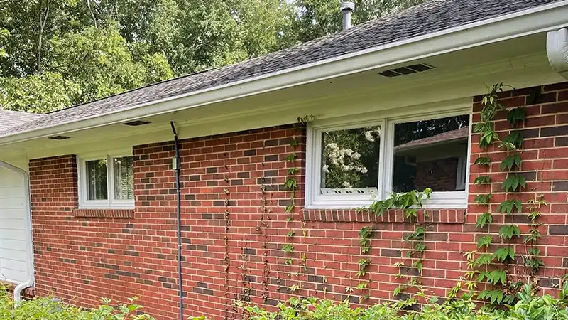 Exterior view of a brick one-story home with white slider windows.